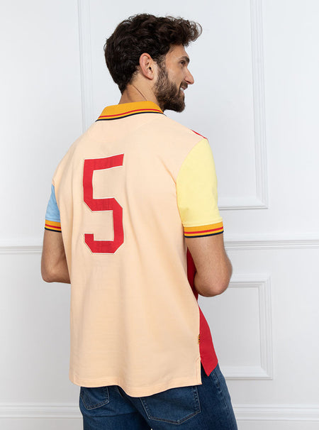 Man wearing multicoloured polo shirt with giant number 5 on the back, made of 100% cotton.